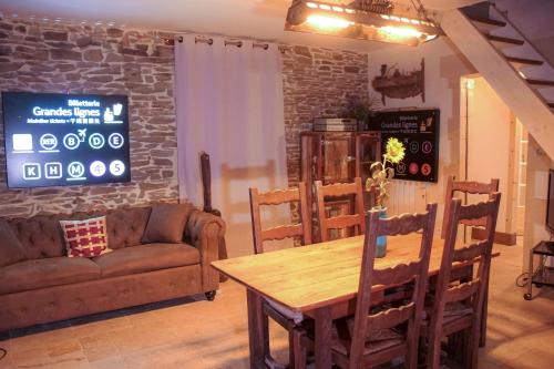 salon z drewnianym stołem i kanapą w obiekcie Cottage with Hot Tube & private Sauna with panoramic view w mieście Les Moutiers-en-Cinglais