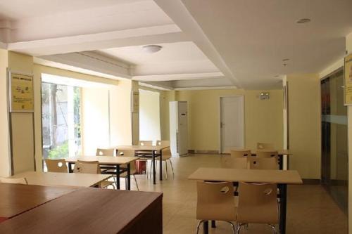 a room with tables and chairs in a classroom at 7Days Inn Hangzhou Xiasha in Hangzhou