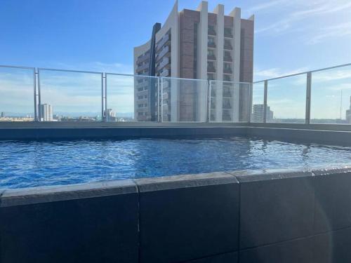 een zwembad voor een hoog gebouw bij Estudio en la zona más bonita de Santa Cruz in Santa Cruz de la Sierra