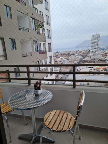 una mesa y sillas en un balcón con vistas en 161 DEPARTAMENTO AMUNATEGUI en Iquique