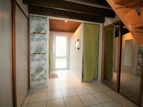 - un couloir dans une maison ornée de papier peint en palmier dans l'établissement Maison avec Jardin près de la Plage, WiFi, 300m du Phare - FR-1-22-291, à La Tranche-sur-Mer