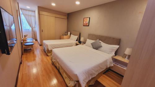 a hotel room with two beds and a window at Coconut Bay Lodge - Beribi in Bandar Seri Begawan