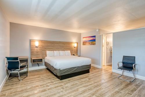 a hotel room with a bed and two chairs at Vagabond Inn San Luis Obispo in San Luis Obispo