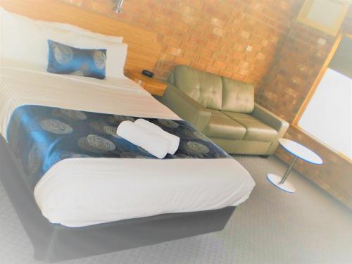 a small bedroom with a bed and a couch at Motel Goolwa in Goolwa