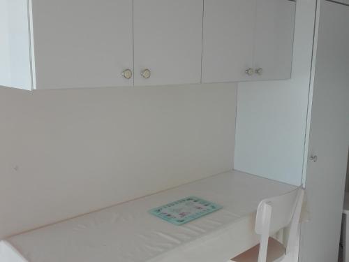 une armoire blanche avec une table et une plaque de cuisson dans l'établissement Studio Face Mer au Cœur des Sables d'Olonne - Balcon Sud, Équipé, 2 pers. - FR-1-331-218, à Les Sables-dʼOlonne