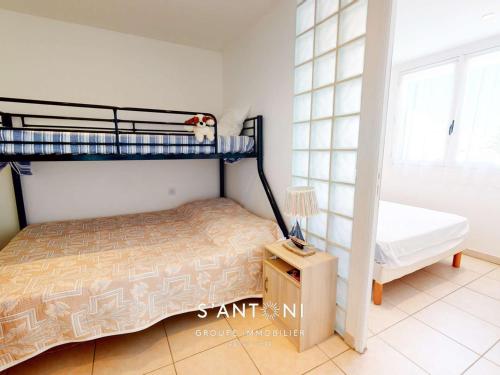une chambre avec deux lits superposés et une table dans l'établissement Grau d'Agde : Appartement 3 pièces en bord de mer - FR-1-423-256, au Grau-dʼAgde