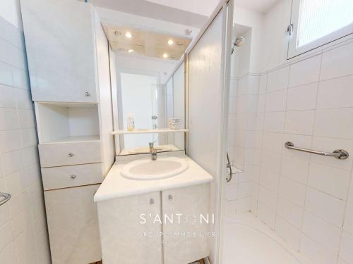 une salle de bain blanche avec un lavabo et une douche dans l'établissement Grau d'Agde : Appartement 3 pièces en bord de mer - FR-1-423-256, au Grau-dʼAgde