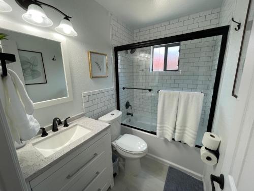 Baño blanco con aseo y lavamanos en Sunrise Experience w/King Size Bed & Pet Friendly, en Roswell