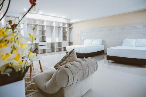 バランカベルメハにあるHotel Súper Estrellasのベッド2台とソファのあるリビングルーム
