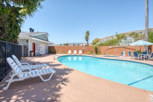 a swimming pool with two lounge chairs next to at Vagabond Inn San Luis Obispo in San Luis Obispo