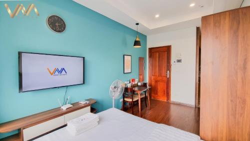 a bedroom with a blue wall with a bed and a table at VNAHOMES Serviced Apartment in Hanoi