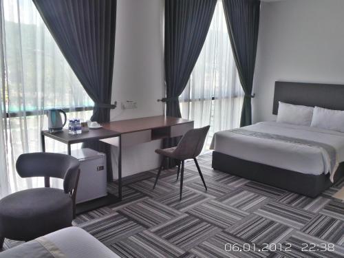 a hotel room with a bed and a desk and chair at We Hotel Langkawi in Kuah