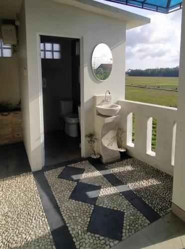 a bathroom with a sink and a toilet and a window at Walasa Ayu Homes By MSH in Piyono