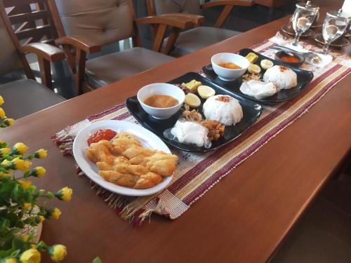 a table with two plates of food on it at Walasa Ayu Homes By MSH in Piyono