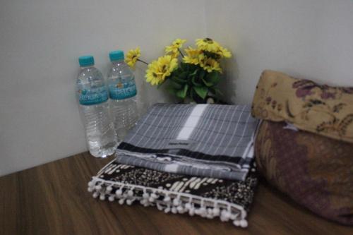 a table with two bottles of water and a vase with flowers at Walasa Ayu Homes By MSH in Piyono