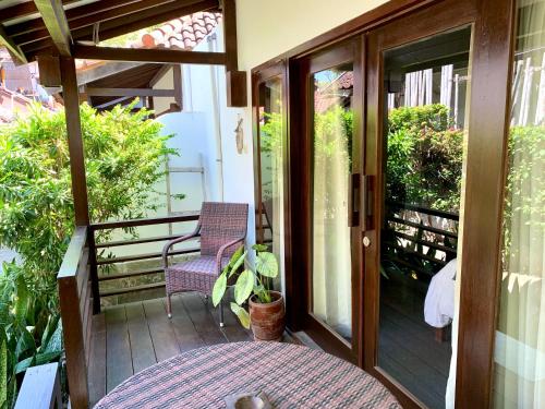 a porch with a glass door and a chair at The Yoga Garden in Gili Trawangan
