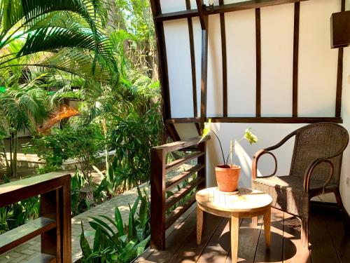 a patio with a table and chairs and a window at The Yoga Garden in Gili Trawangan