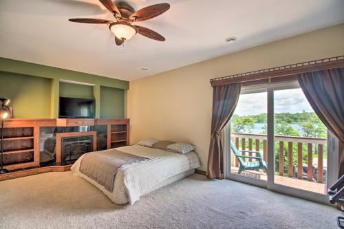 a bedroom with a bed and a fireplace and a balcony at Spacious Frazee Home with Direct Lake Access! in Frazee