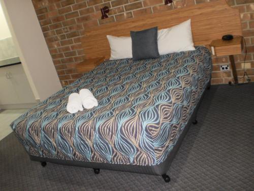 a bedroom with a bed with two towels on it at Motel Goolwa in Goolwa
