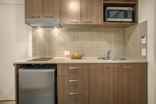 a kitchen with a sink and a microwave at Hudson Parap in Darwin