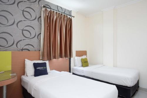 Tempat tidur dalam kamar di Urbanview Hotel Capital Makassar