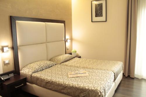 a hotel room with a bed with a book on it at Catone District Hotel in Rome
