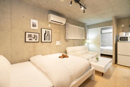 a bedroom with a white bed and a couch at Shinjuku area Industrial Chic apartment Walk 6min To Station in Tokyo