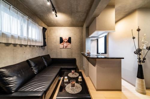 a living room with a black leather couch at Shinjuku area Industrial Chic apartment Walk 6min To Station in Tokyo