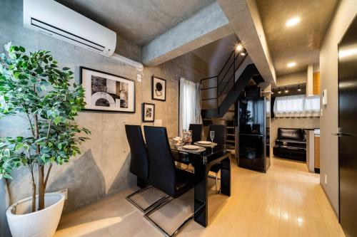 a dining room with a black table and a plant at Shinjuku area Industrial Chic apartment Walk 6min To Station in Tokyo