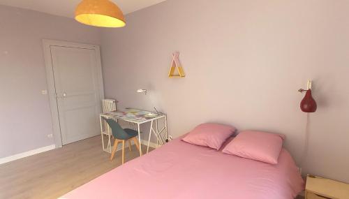 a bedroom with a pink bed and a desk at Histoire de Loire - ANJOU sdb partagée in Saumur