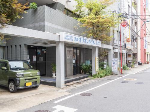 einem grünen LKW, der vor einem Gebäude parkt in der Unterkunft Nagasaki Orion Hotel in Nagasaki