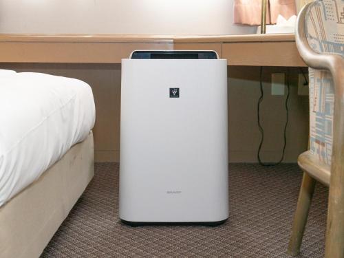 a white refrigerator sitting on the floor next to a bed at Nagasaki Orion Hotel in Nagasaki
