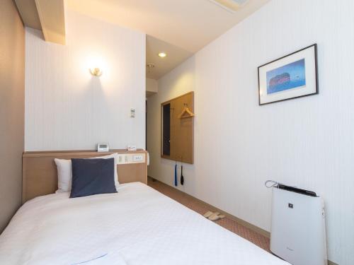 a small room with a bed and a picture on the wall at Nagasaki Orion Hotel in Nagasaki