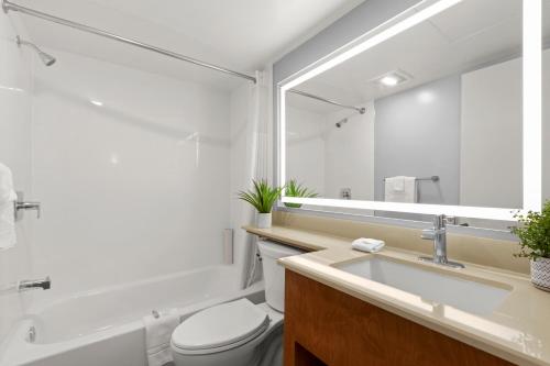 uma casa de banho com um lavatório, um WC e um espelho. em Good Nite Inn Redwood City - San Francisco Airport em Redwood City
