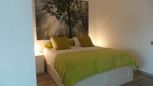 Un dormitorio con una cama con una manta verde. en Ventur Balcony, en Caniço