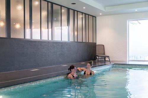 two children playing in a swimming pool at ibis Styles Nieuwpoort in Nieuwpoort