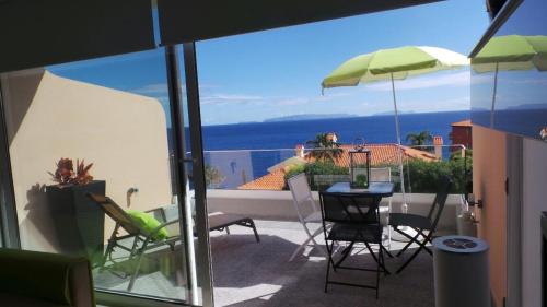 a balcony with a table and chairs and an umbrella at Ventur Balcony in Caniço