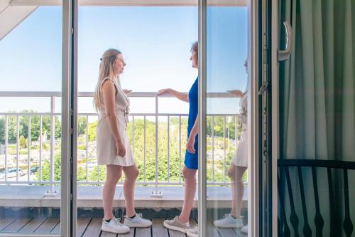 two women standing on a balcony looking out the window at ibis Styles Nieuwpoort in Nieuwpoort