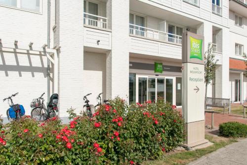a white building with bikes parked outside of it at ibis Styles Nieuwpoort in Nieuwpoort