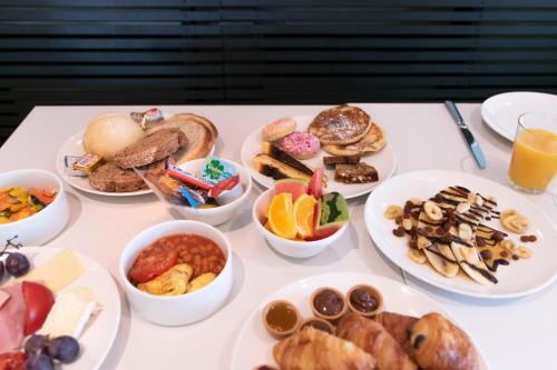 a table topped with plates of different types of food at ibis Styles Nieuwpoort in Nieuwpoort