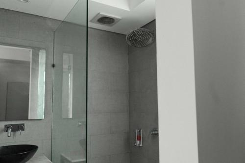 a bathroom with a glass shower stall and a sink at Villa Kalma Canggu in Canggu