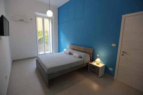 - une chambre bleue avec un lit et une fenêtre dans l'établissement casa Elodie, à Naples