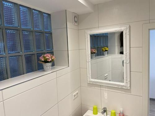 bagno bianco con lavandino e specchio di Ferienwohnung Beutelsbacherstr. 12 B a Stoccarda