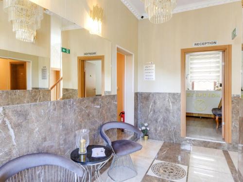 a salon with two chairs and a table and a mirror at Deluxe apartment in Oberhausen with terrace in Oberhausen