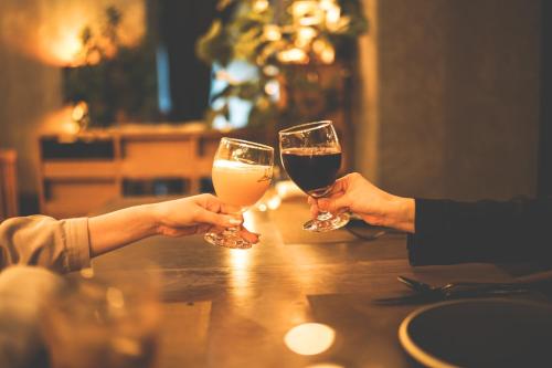 two people holding glasses of wine sitting at a table at Twin-Line Hotel Karuizawa Japan in Karuizawa