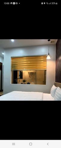 a bedroom with a white bed and a mirror at Hotel The Quin in Hai Phong