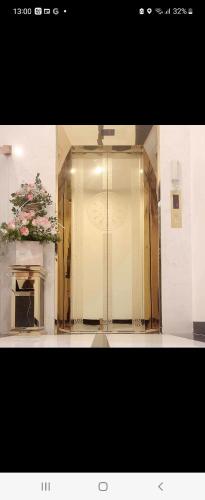 a glass door in a room with a plant at Hotel The Quin in Hai Phong