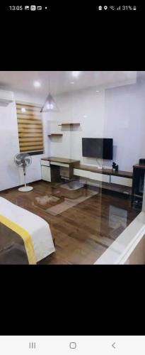 a living room with a television and a desk at Hotel The Quin in Hai Phong
