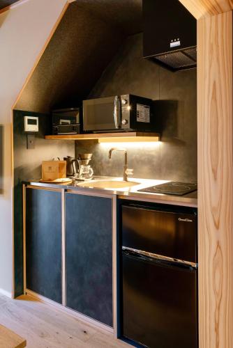 a kitchen with a sink and a stove at Hanatsume Machiya House in Kanazawa