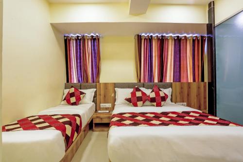two beds in a room with colorful curtains at BKC Corporate Hostel Ac Dormitory in Mumbai